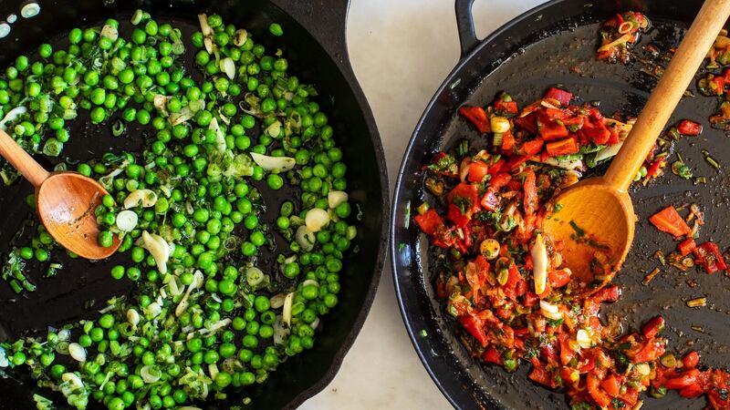 Peas and roasted peppers are prepared for use in a cheesy potato cake. Photograph: Andrew Scrivani/The New York Times
