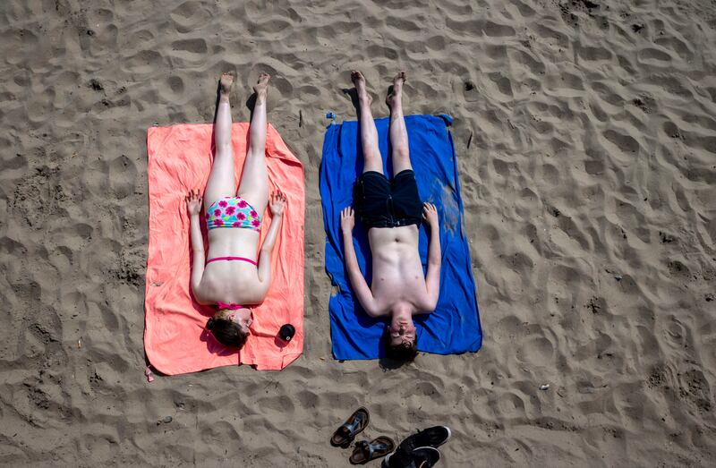 People sunbathing on Portmarnock beach in Dublin. Photograph: Tom Honan