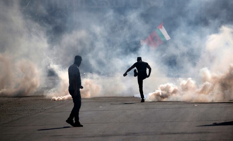 A Palestinian kicks away a tear gas canister during clashes with Israeli forces in the West Bank city of Nablus on Friday. Photograph: Alaa Badarneh 