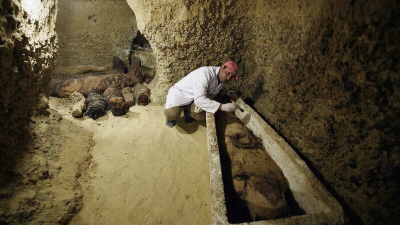 An archaeologist works on a mummy at Tuna el-Gebel archaeological site. Photograph: EPA