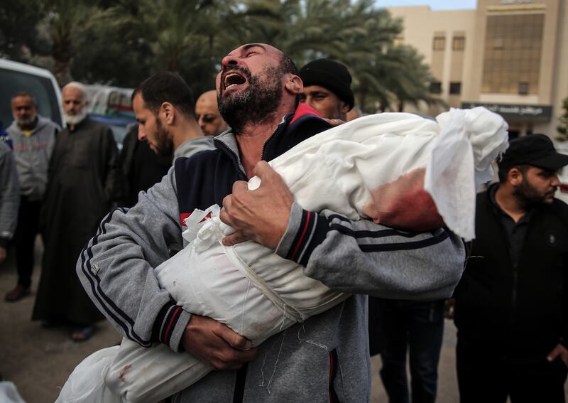 A man grieves while cradling the body of a child killed in an Israeli air strike during a funeral in Khan Younis, in the southern Gaza Strip. Photograph: Yousef Masoud/New York Times
                      
