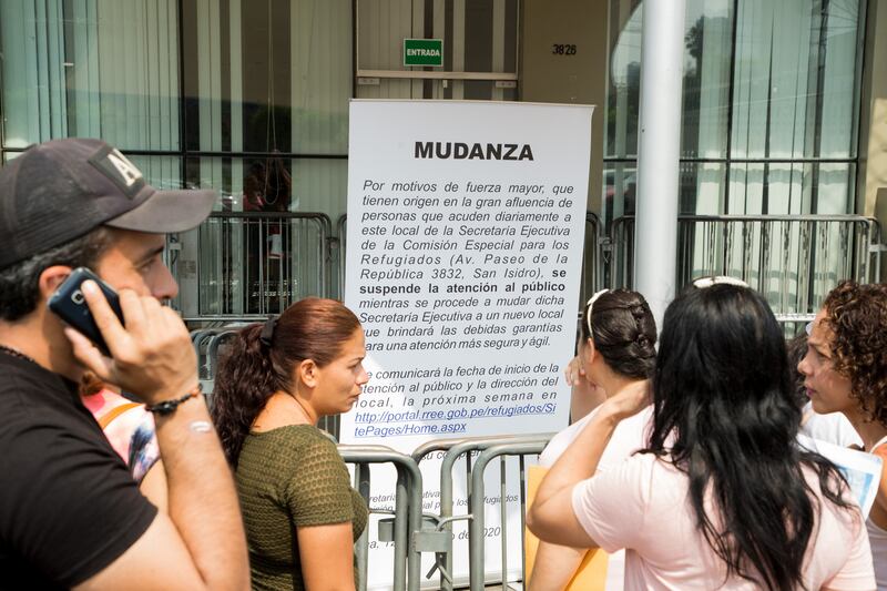 Refugees from Venezuela read a notice announcing the closure of the asylum claims office in Lima, Peru. Some had shown up for appointments without knowing that the office had been closed. Photograph: Paul Musiol