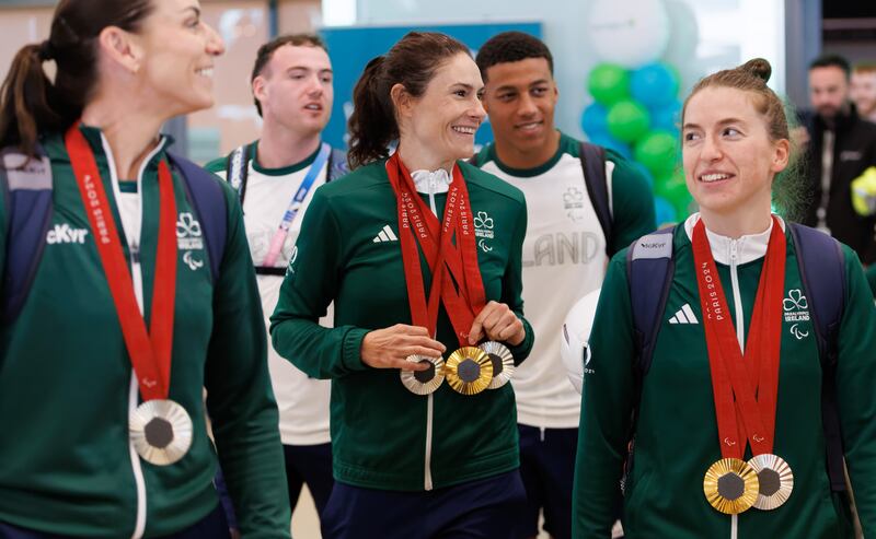 Cyclist Katie-George Dunlevy with her two silver medals and one gold, alongside her pilots Eve McCrystal and Linda Kelly, at the Team Ireland Paralympics homecoming after the 2024 Paris Paralympic Games at Dublin Airport on Monday. Photograph: James Crombie/Inpho