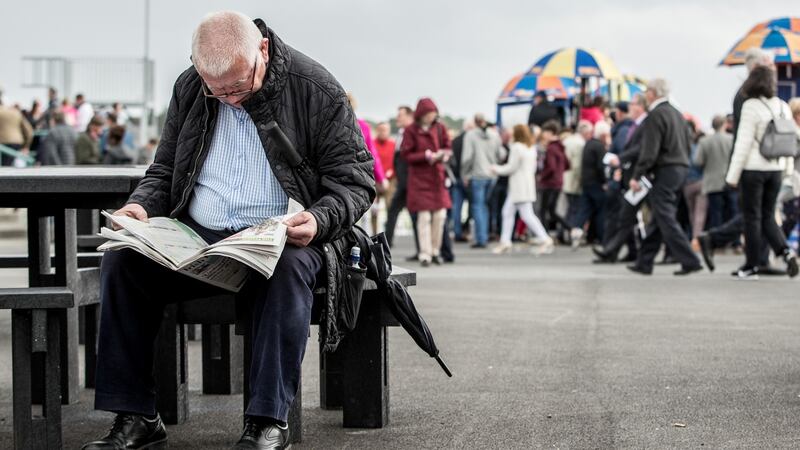 A punter reads in on the  second day of the Galway Racing Festival at Ballybrit. Photograph: James Crombie/Inpho