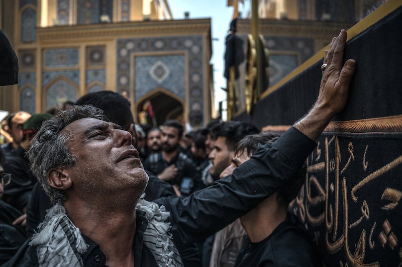 A mourner weeps as touches the truck carrying the coffin of Ayatollah Ali Khamenei in Najaf, Iraq. Photograph: Sergey Ponomarev/The New York Times