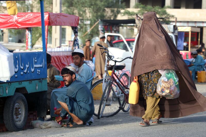 A woman walks past a vendor selling cooked rice on a roadside in Kandahar, Afghanistan, on July 20th. Photograph: EPA-EFE