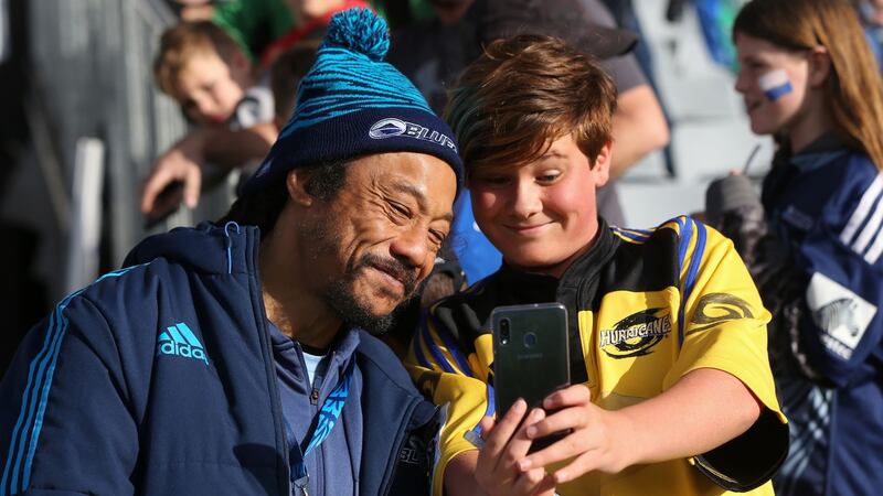 Auckland Blues assistant coach Tana Umaga poses for a photo with a fan at Eden Park stadium. Photograph: Getty Images