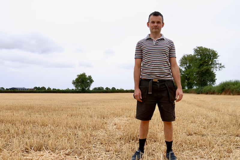 Farmer James Brennan in a wheat field, which had to be cut early because of the lack of rain
