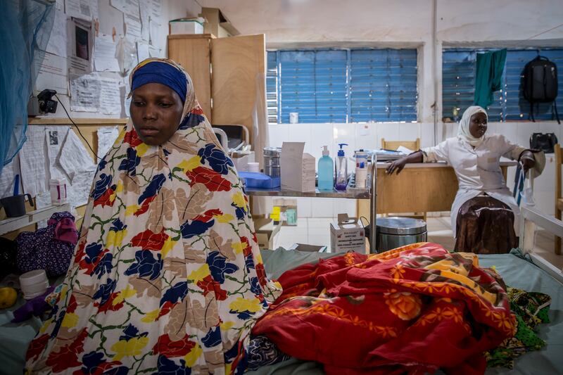 Harira Moussa sits beside her two-year-old son, who is wrapped up in blankets, in the hospital's intensive care room. Photograph: Sally Hayden