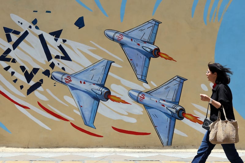 An Iranian woman walks next to a anti-US and Israel mural in a street in Tehran on Friday. Photograph: Abedin Taherkenareh/EPA