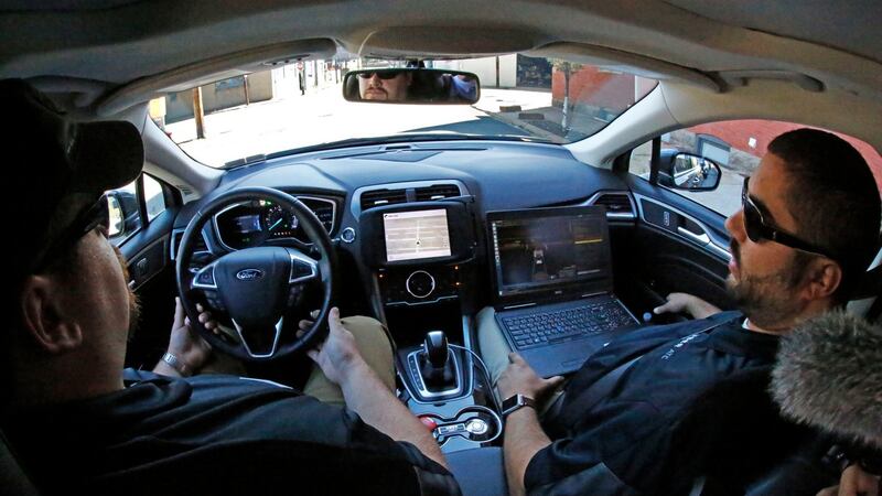 Uber safety driver Zachary Rearick, left, and vehicle operator Paul Rocchini take journalists on a drive through the streets of downtown Pittsburgh in a self driving Uber. Dozens of self-driving Ford Fusions will pick up riders who opted into a test programme with Uber. While the vehicles are loaded with features that allow them to navigate on their own, an Uber engineer will sit in the driver’s seat and seize control if things go awry.