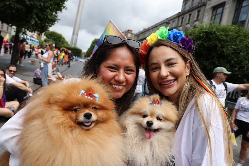 Nicoll Medrano (left) and Nathalia Salvador with dogs Sol and Luna  in the Pride Parade in Dublin City centre. Photo: Bryan O’Brien / The Irish Times  
