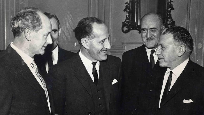 An tAire Tráchtála Jack Lynch, Príomh-Aire Thuaisceart Éireann Terence O'Neill, an tAire Gnóthaí Eachtracha Frank Aiken agus an Taoiseach Seán Lemass ag Teach Uíbh Eachach in 1965. Grianghraf: Joe Clarke