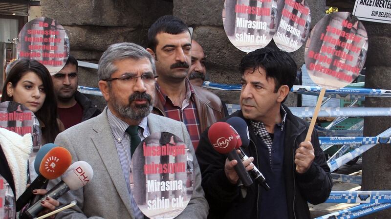 Tahir Elci   speaks to the media shortly before being shot and killed in Diyarbakir, Turkey. He  holds a placard that reads: “Let’s protect humanity heritage.” Photograph: Ilyas Akengin/AP
