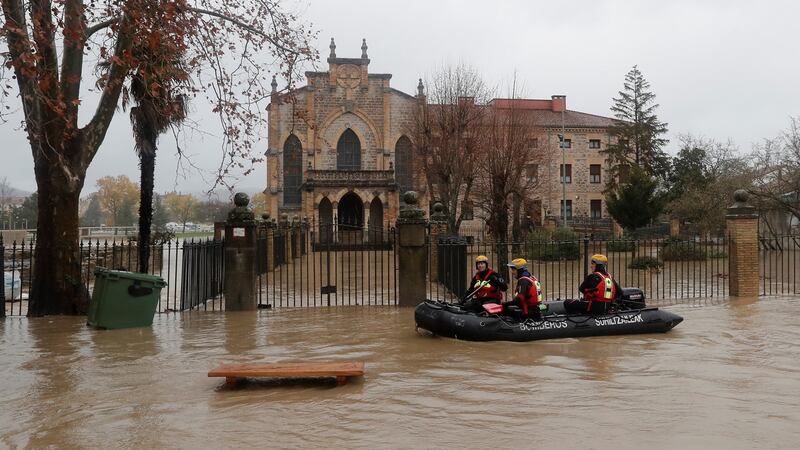Firefighters use a dinghy to inspect the flooded streets in Pamplona. Photograph: Villar Lopez/EPA