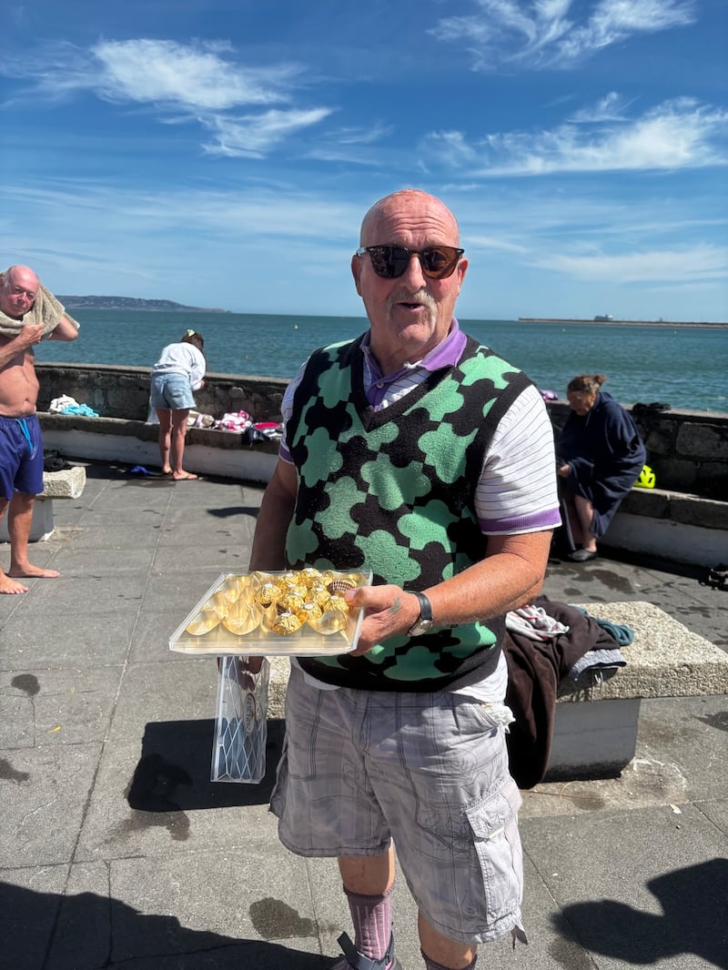 Jim Doyle, who said he has been stung by jellyfish many times, passes around chocolates after his morning swim at the Martello tower at Seapoint, Co Dublin. Photograph: Tim O'Brien