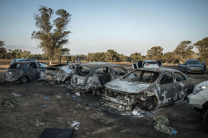 Burned-out vehicles at the camp site, only three miles from Gaza, for the Tribe of Nova gathering, a trance music festival that was attacked by Hamas militants, near the Re'im kibbutz in Israel. Photograph: Sergey Ponomarev/The New York Times
                      