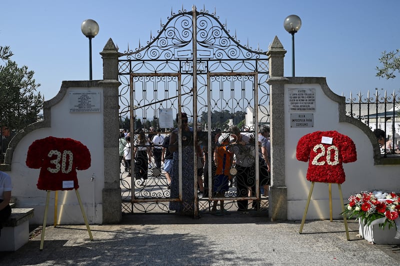 Wreath in shape of football jerseys are displayed at the entrance of the cemetery after the funeral ceremony. Photograph: Miguel Riopa/AFP/Getty