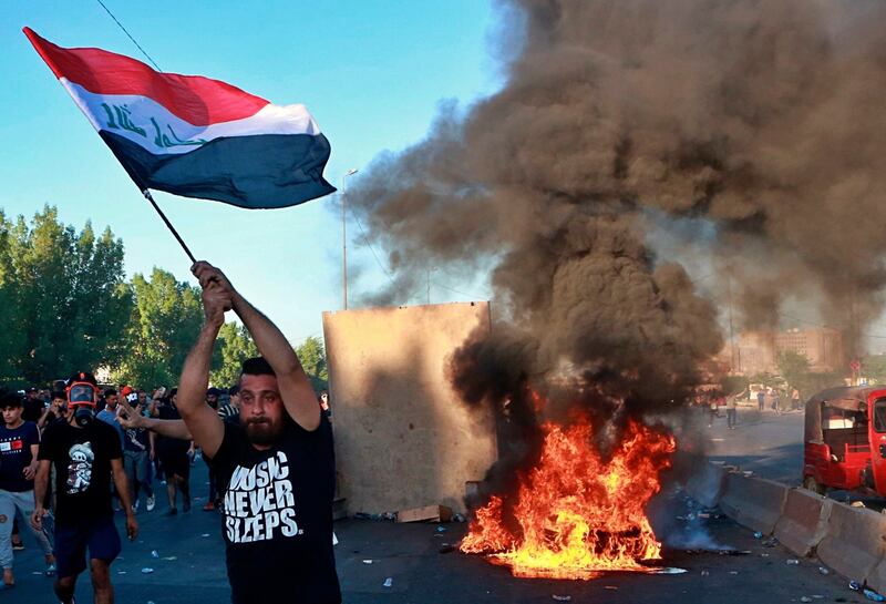 Anti-government protesters set fires and close a street during a demonstration in Baghdad on Friday. Photograph: Khalid Mohammed/AP