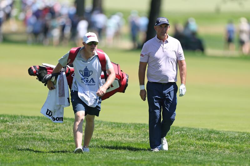 Pádraig Harrington of Ireland and his caddie Ronan Flood walk the 12th hole. Photograph: Andrew Redington/Getty