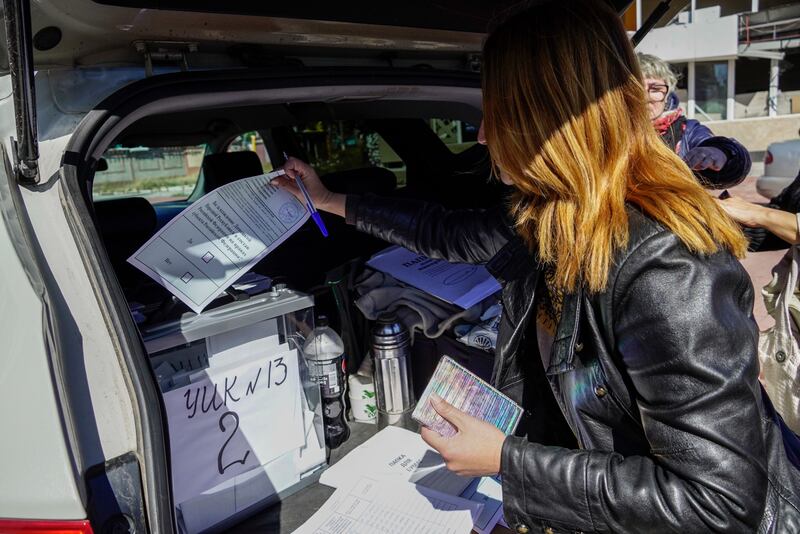 A woman casts her ballot in a box set up in the back of a car during voting in a referendum on the joining of Russian-controlled regions of Ukraine to Russia. Photograph: EPA