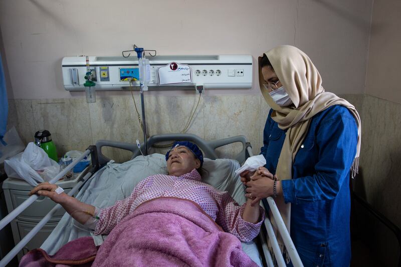 A woman holds the arm of her mother, who was wounded by airstrikes on a highway bridge near Tehran, Iran, at Imam Ali Hospital in Karaj, Iran, on Friday. On Thursday, the US struck the highway bridge near the capital, and Iranian news outlets reported eight people were killed. Photograph: Arash Khamooshi/The New York Times
                      