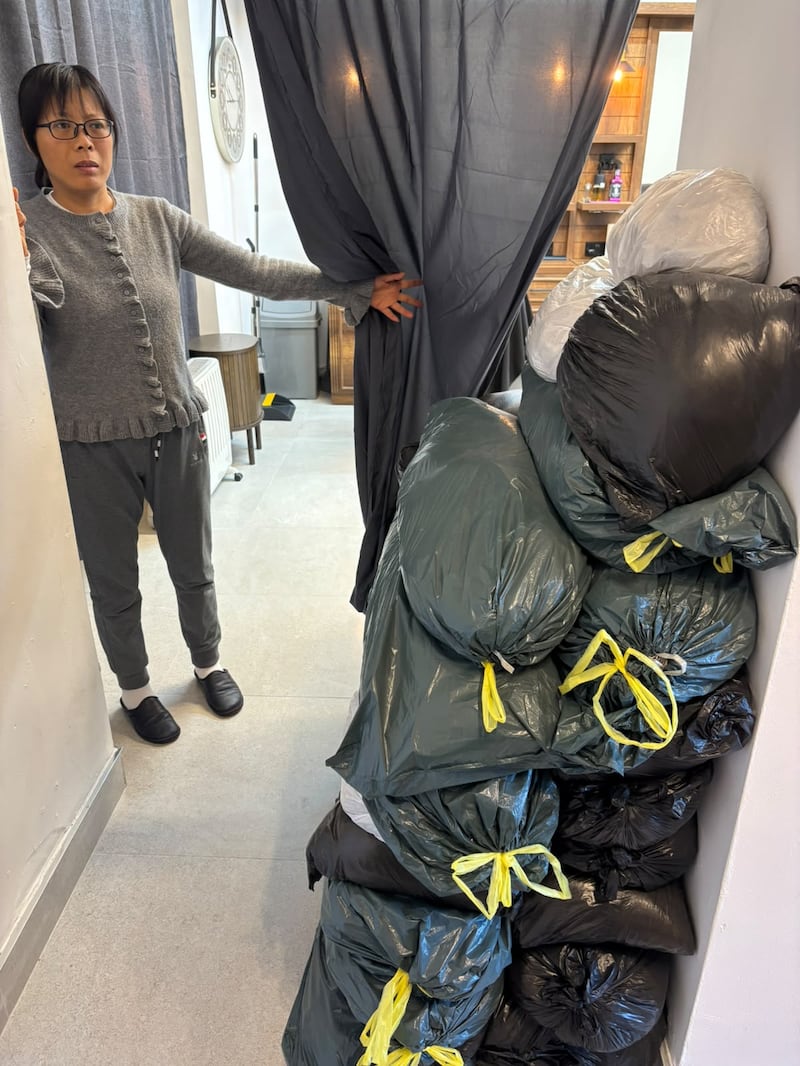 Zara Chunli Zhang with sandbags on the premises of her business, Temple Barbers. Photograph: James Cox