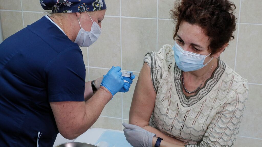A Russian medical worker gives a trial vaccine against Covid-19 to a volunteer in Moscow.