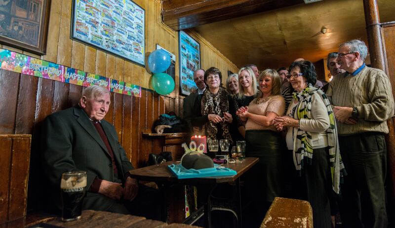 George Smith celebrating his 100th birthday in John Kavanaghs in Glasnevin, commonly known as The Gravediggers, with his family and friends in January 2015. George has been going to this pub every week for the past 60 years. Photograph: Brenda Fitzsimons
