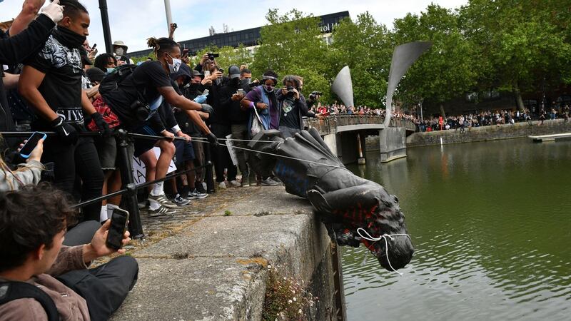 A statue of Edward Colston is thrown by protesters into Bristol harbour during a Black Lives Matter protest rally on Sunday. Photograph: Ben Birchall/PA Wire