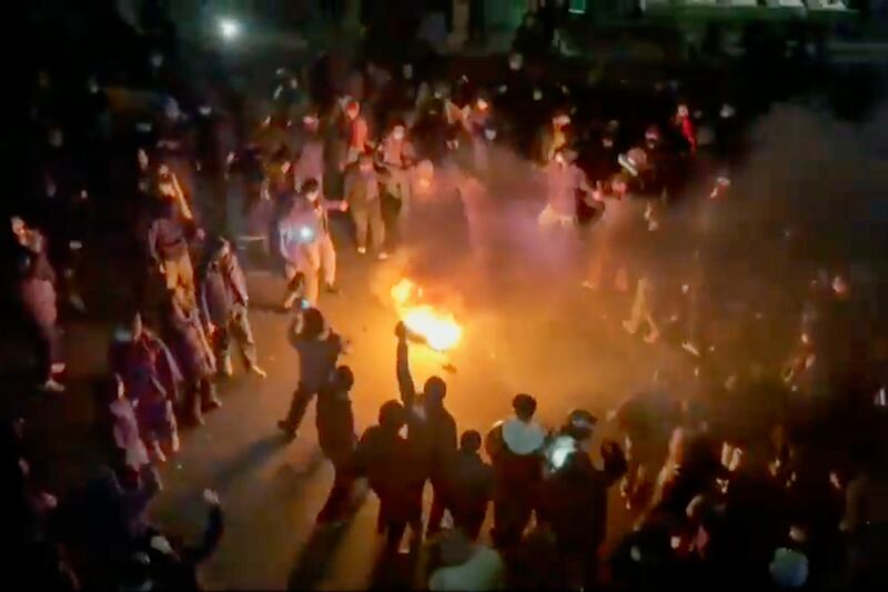 A frame grab from footage circulating on social media shows protesters dancing and cheering around a bonfire. Photograph: AP