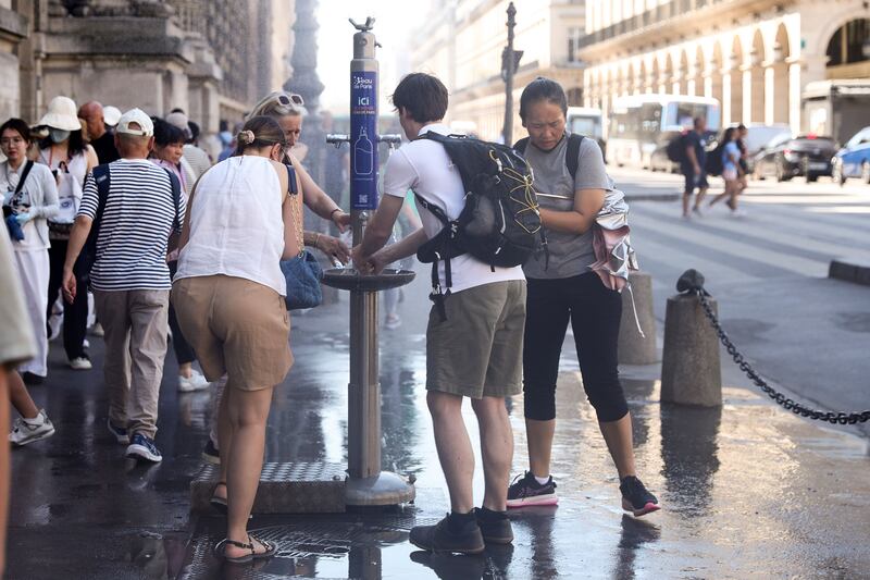 People try to cool off at a water point set up by the City of Paris near the Louvre. Photograph: Teresa Suarez/EPA