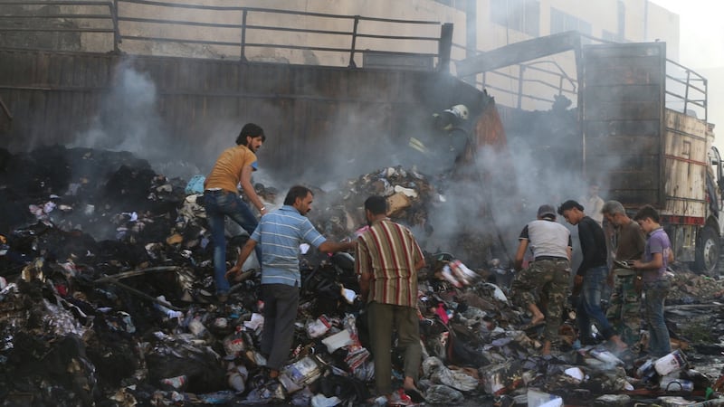 People salvage goods from an aid convoy that was damaged during an airstrike in the rebel-held area of al-Sakhour district of Aleppo, Syria. Photograph: Abdalrhman Ismail/Reuters