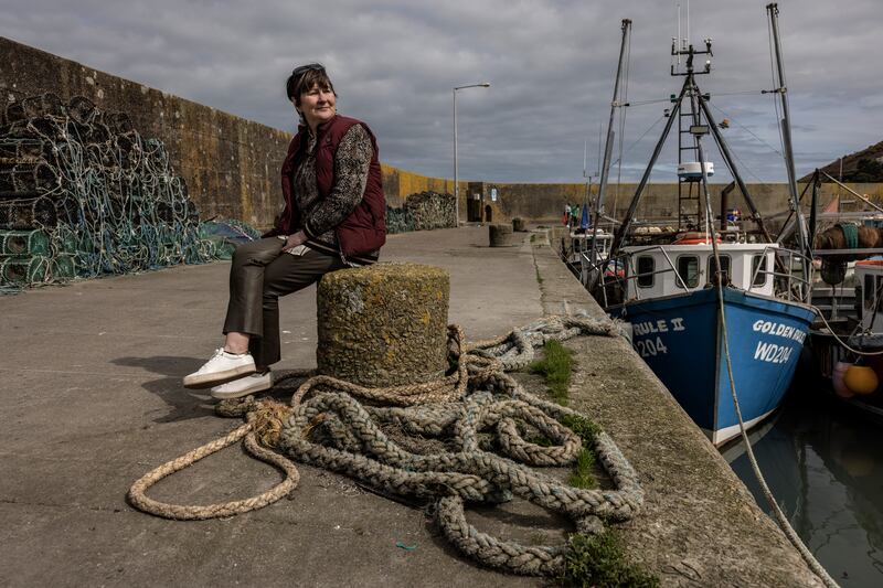 Caitlín Uí Aodha, a fishing vessel owner and skipper, at the pier near her home in  Helvick. Photograph: Finbarr O'Reilly/New York Times
                      