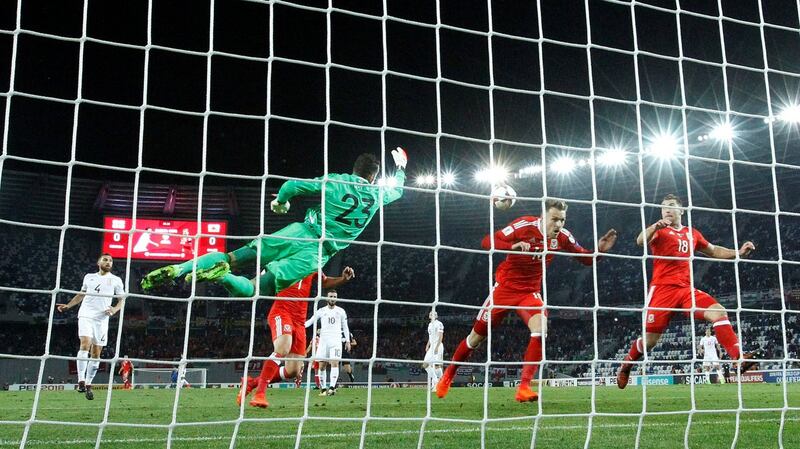 Georgia’s Giorgi Loria punches clear of Wales’ Aaron Ramsey and Sam Vokes. Photograph: David Mdzinarishvili/Reuters