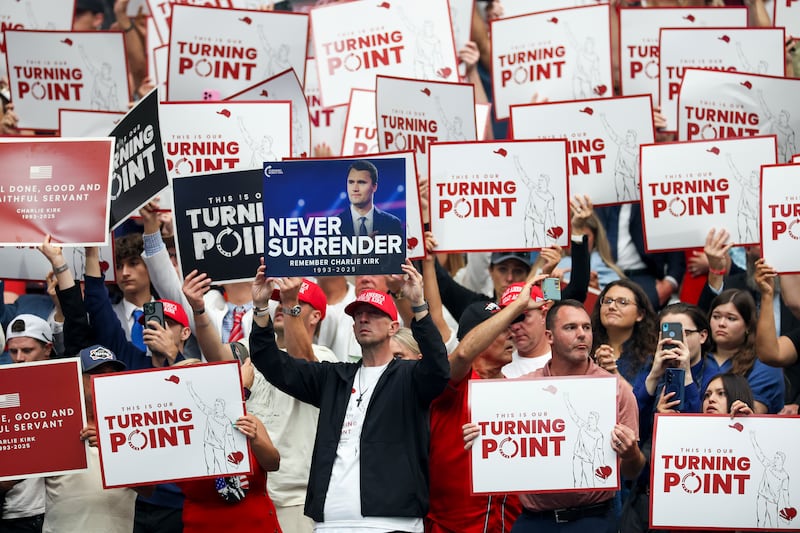 Attendees hold up signs at the memorial service for political activist Charlie Kirk at State Farm Stadium in Arizona. Photograph: Joe Raedle/ Getty Images