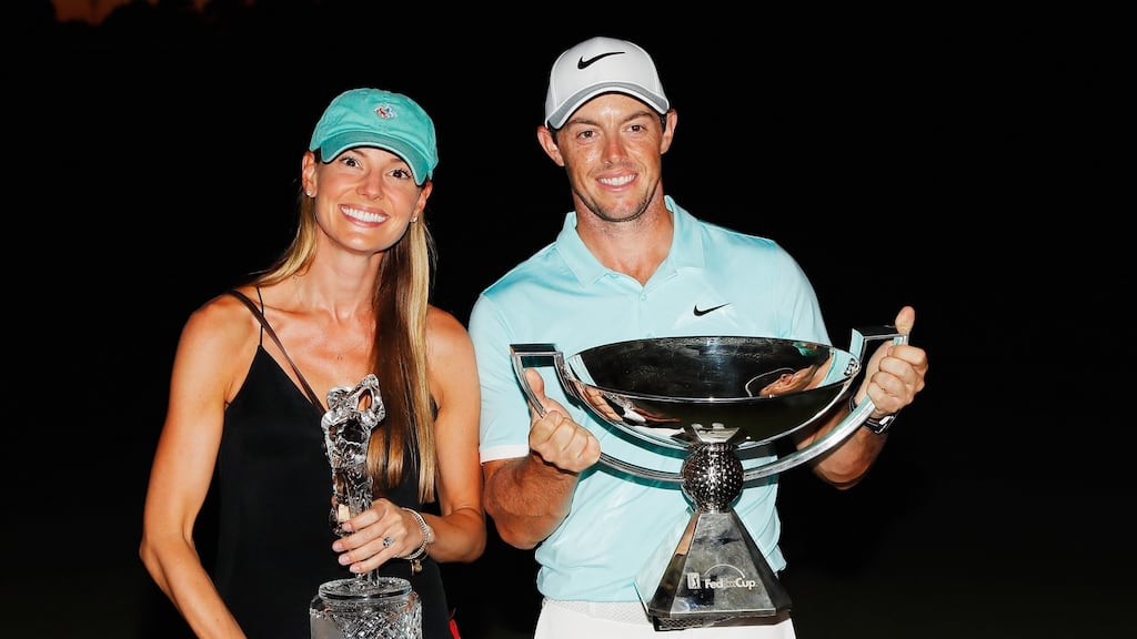 Rory McIlroy of Northern Ireland poses alongside his girlfriend Erica Stoll and the FedExCup and TOUR Championship trophies after his victory over Ryan Moore with a birdie on the fourth extra hole during the TOUR Championship at East Lake Golf Club in Atlanta, Georgia. Photo: Kevin C. Cox/Getty Images