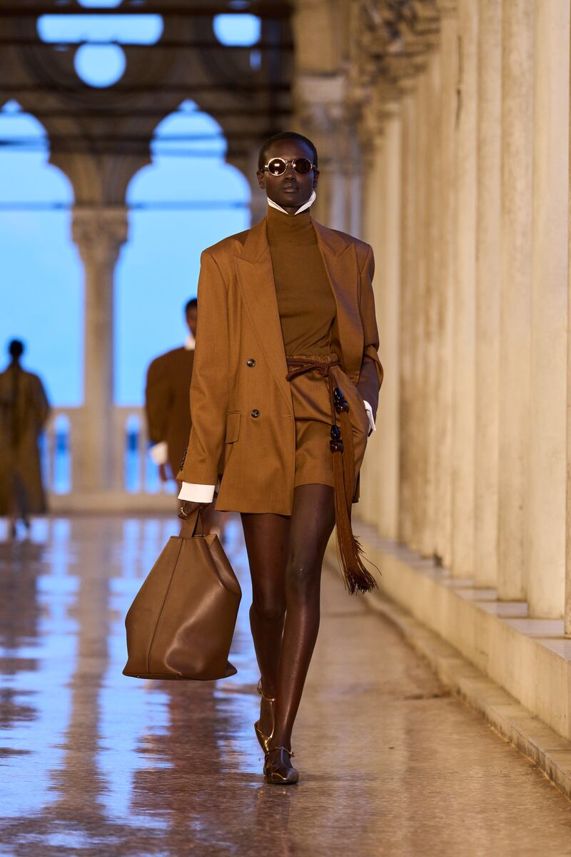 Brown double-breasted blazer, €1,130, worn with belted mini skirt, €450, high-neck top, €325, with collar and arm cuffs, €170