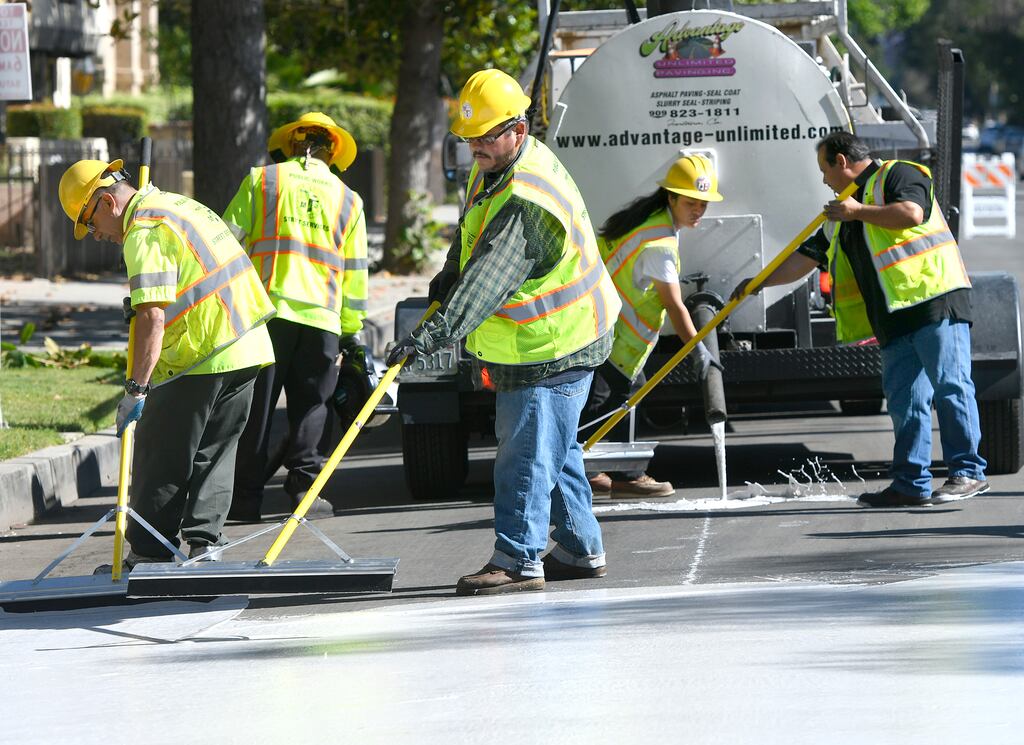 Workers coat a California street in a concrete colour designed to reflect heat. Photograph: John McCoy/MediaNews Group/Los Angeles Daily News via Getty Images