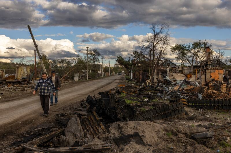 Ukrainians walk past a destroyed Russian tank in the recaptured village of Yatskivka on October 4th. Photograph: Ivor Prickett/New York Times