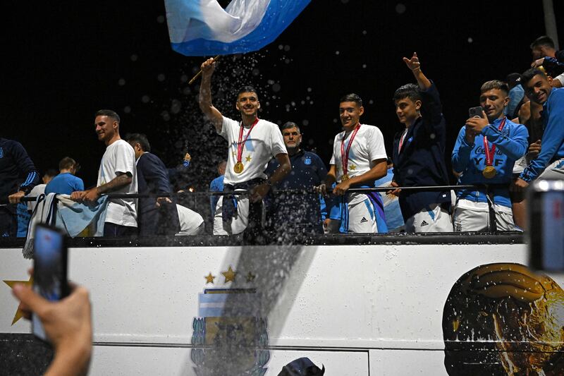 Argentina's players celebrate on board a bus after winning the Qatar 2022 World Cup tournament as they leave Ezeiza International Airport. Photograph: Luis Robayo/AFP via Getty