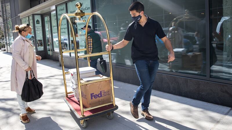 A  district attorney  investigator carries boxes of documents and a laptop from Jennifer Weisselberg (left) outside her apartment in Manhattan, New York, on April 8th. Photograph: Jeenah Moon for the Washington Post via Getty Images