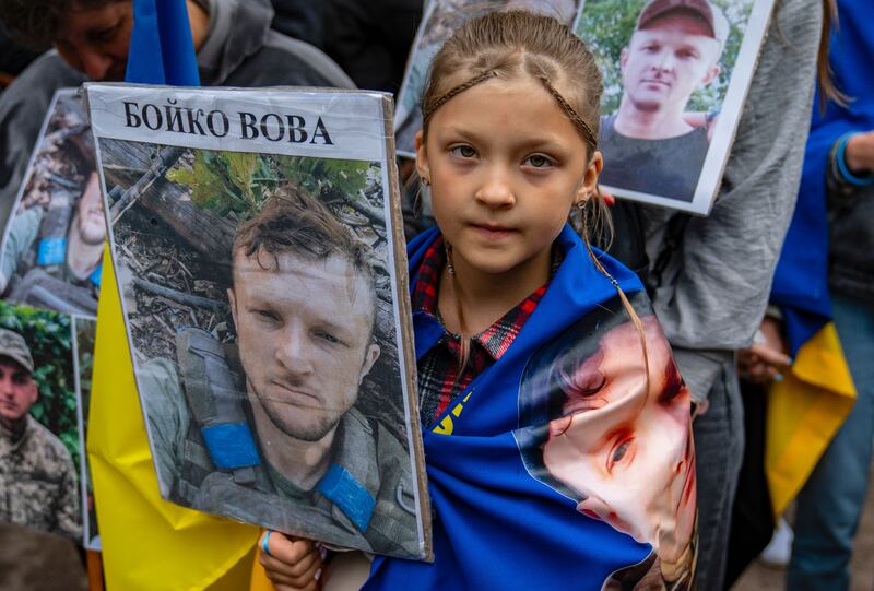 A Ukrainian girl holds up a portrait of a missing relative to released Ukrainian prisoners of war following a prisoner-swap in Ukraine on Sunday. Photograph: EPA