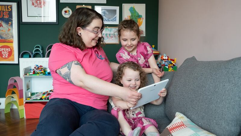 Tara and daughters Neeta and Rosa play on their iPad