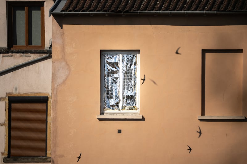 Birds fly past a window hidden by an emergency blanket during a heatwave in Lyon, central-eastern France. Photograph: Olivier Chassignole/AFP via Getty Images