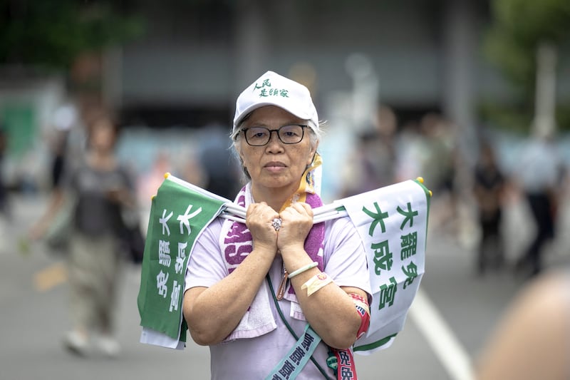 A woman holds flags while waiting for the results of the recall election in Taipei. Photograph: I-Hwa Cheng/AFP via Getty