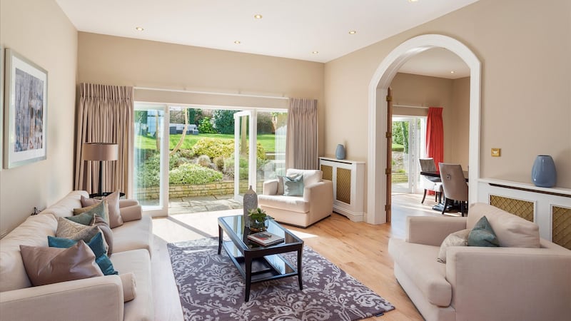 A large family room at the back of the house is one of three separate but linked rooms  which all have French doors opening into the back garden