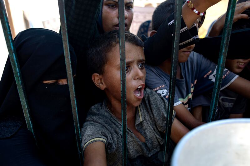 Palestinian women and children wait to collect food donated by a charity in Khan Younis camp, southern Gaza Strip.  Photograph: Haitham Imad/EPA