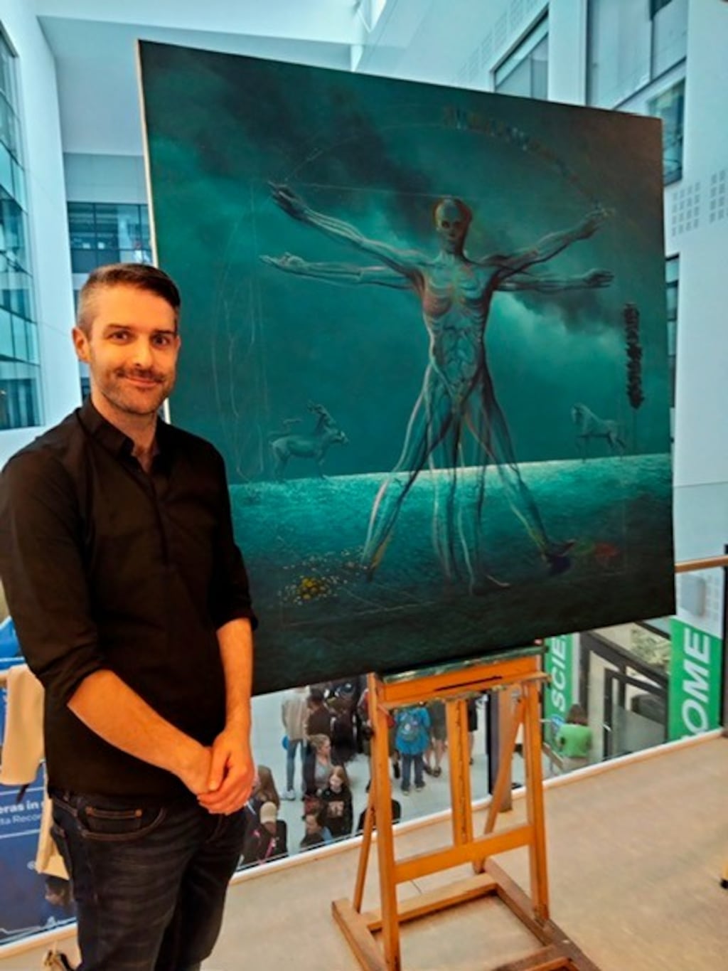 Artist Vincent Devine with his work, The Vitruvian. He worked with cancer researchers and patients to create the painting.