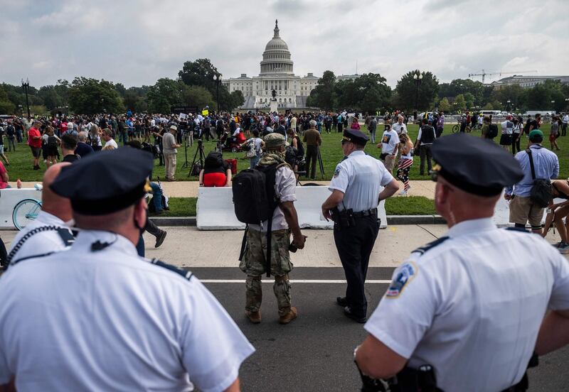 Police officers watch  demonstrators taking part in the ‘Justice for J6’ rally in Washington DC on Saturday. Photograph:  Andrew Caballero-Reynolds/AFP via Getty